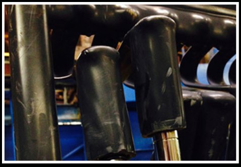 Shafts on a plating rack, each gear end covered by a custom mask